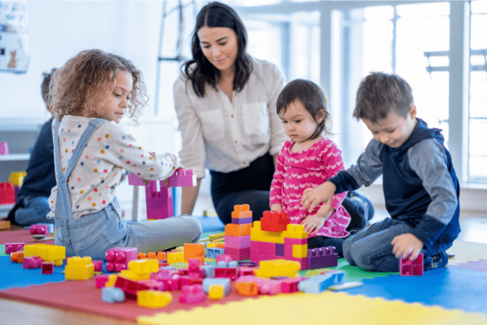 Woman providing in-home childcare for 3 young children