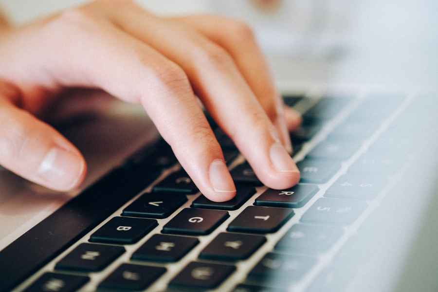 hand typing a laptop keyboard