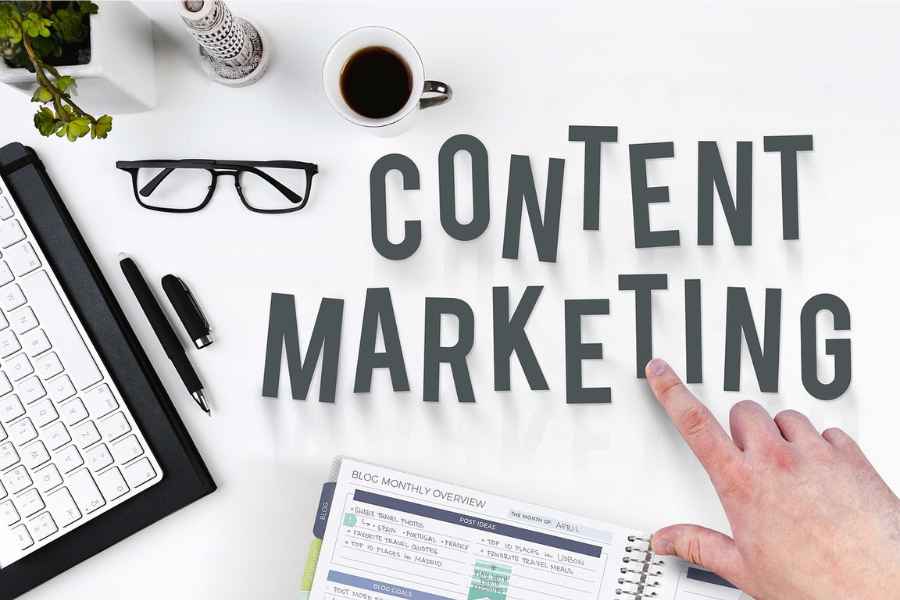 the words "content marketing" on a backdrop with a keyboard, coffee, utensils