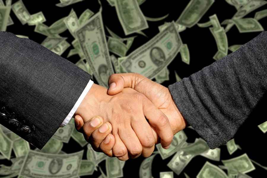handshake in front of floating money