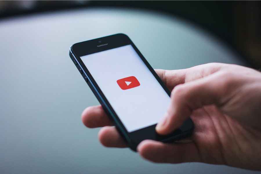 youtube icon on cell phone held by hand 